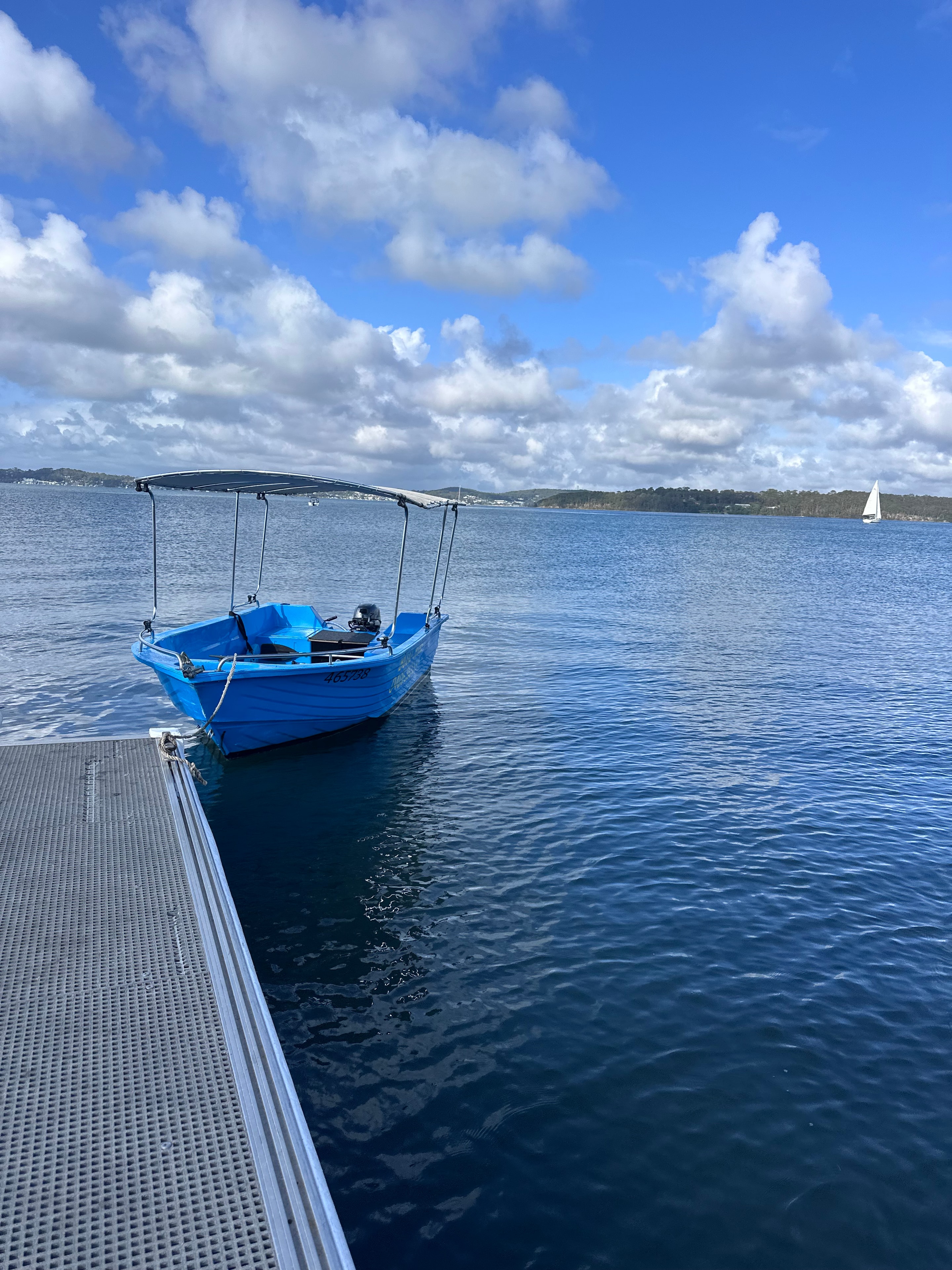 Blue hire boat tied up at the Warners Bay jetty on Lake Macquarie