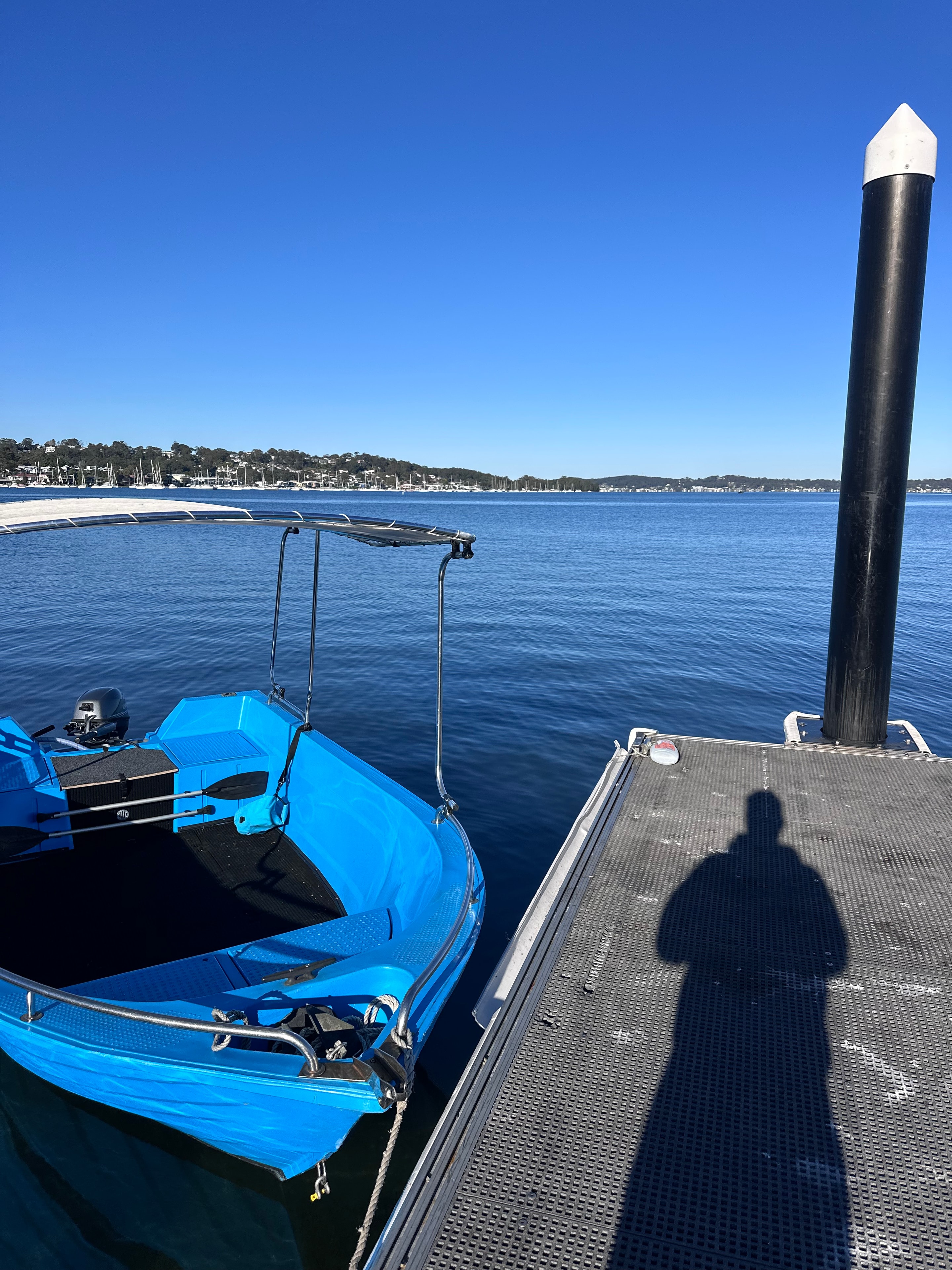 Our blue hire boat moored at the dock on Lake Macquarie
